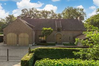 <p>Gelegen in een rustige en elegante laan met karaktervolle villa’s op royale percelen, bevindt zich deze instapklare villa met verwarmd buitenzwembad. De woning geniet van een uitzonderlijke ligging in een groene, natuurrijke omgeving, pal aan het Zoerselbos, waar rust en privacy centraal staan. Tegelijk zijn alle nodige voorzieningen en een vlotte bereikbaarheid binnen handbereik, wat deze locatie tot een zeldzame combinatie van natuur en comfort maakt.<br /><br /></p>
<p><strong>Indeling:<br /></strong><br />Inkomhal met gastentoilet. Enerzijds is er toegang tot de leefkeuken, anderzijds tot de leefruimte. De leefruimte is ingedeeld in een ruim salon met open haard, open tot in de nok van het dak, een eetkamer en een aparte bureauruimte. Deze laatste biedt op haar beurt toegang tot de dubbele inpandige garage en de wasplaats/technische ruimte.</p>
<p>De luxueus ingerichte leefkeuken is hypergeïnstalleerd en voorzien van alle hedendaags comfort (ijskast, diepvriezer, wijnkast, inductiekookplaat, dubbele dampkap, ruime traditionele oven, combi-oven, stoomoven, warmhoudlade, dubbele spoelbak en aanrecht- en werk-/eeteiland in composiet, …).</p>
<p>Vanuit de keuken is er toegang tot het overdekte en afsluitbare terras met open haard, dat op zijn beurt toegang biedt tot een extra garage. Aan de andere zijde van de woning bevindt zich bovendien een ruime carport.</p>
<p><strong>Verdieping:<br /></strong><br />Overloop met toegang tot de hoofdslaapkamer met dubbele dressing en een ruime badkamer en suite (ligbad, inloopdouche, dubbele lavabo en toilet). Slaapkamers 2 en 3 beschikken over een aangewerkt bureau, een ingemaakte kastenwand en een communicerende badkamer met twee lavabo’s, ligbad en douche. Verder is er nog slaapkamer 4, een aparte wasplaats en een nachttoilet op de gang.</p>
<p>De mooi aangelegde tuin met recent vernieuwde terrassen is volledig omheind. Het zwembad wordt verwarmd via een warmtepomp.<br /><br />Beschikbaar vanaf zomer 2027.</p>
<p><strong>Bijzonderheden:<br /></strong><br />Automatische toegangspoort – bevloering in natuursteen en parket – vloerverwarming en centrale verwarming op mazout (Buderus) – dubbele beglazing – houten ramen – hoge plinten – ventilatiesysteem D – airconditioning – dakisolatie – geïsoleerde bergzolder – recent uitgevoerde schilderwerken – overal LED-verlichting – kruipruimte – alarm en buitenalarm – camerabewaking – domotica – elektriciteit conform – <strong>BESCHIKBAAR </strong>zomer 2027 - EPC-label B- 133 kWh/m² – Vg-Wp-Vv-Gvkr-Gmo-Gworg.</p>