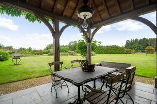  Deze exclusieve villa is gelegen op een prachtig terrein van ruim 1,3 Ha met vijver en parktuin alsook weide voor paarden. U rijdt de poort binnen...