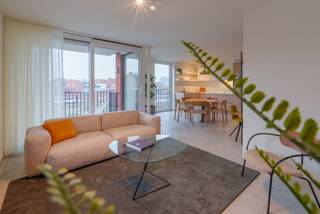 Ben je op zoek naar een nieuwe thuis of een interessante investering in het hart van Ingelmunster? Ontdek dit energiezuinige en moderne nieuwbouwappartement in Residentie Geuze St. Louis, gelegen op de historische brouwerijsite van Brouwerij Vanhonsebrouck.
Je woont in het centrum, op wandelafstand van winkels, scholen, horecagelegenheden, het gemeentehuis, openbaar vervoer en het station. Zin in een ontspannende wandeling of fietstocht? Het nabijgelegen kanaal Roeselare-Leie en de prachtige Mandelvallei bieden een oase van rust en natuur.
Dit appartement (91,54 m² woonoppervlakte) op de tweede verdieping beschikt over een inkomhal, een lichtrijke woon- en eetkamer, een geïnstalleerde open keuken, een praktische berging, 2 slaapkamers, een functionele badkamer en een mooi terras. Dankzij de hoge plafonds (2,5m tot 3m hoog!) en de hoge ramen geniet je van veel lichtinval en een ruimtelijk gevoel. De privé parkeerplaatsen zijn ondergebracht in een afzonderlijke, veilige parkeerhaven achter het gebouw. Je fiets kan je stallen in een gemeenschappelijke fietsenberging.
Contacteer ons voor meer informatie of een bezoek ter plaatse.