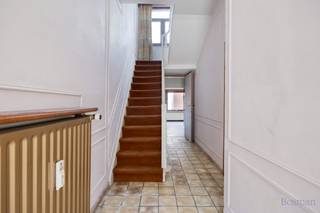 <strong>Halfopen bebouwing met 5 garageboxen te koop in Ham</strong><br /><br />Deze woning is gelegen in het centrum van Kwaadmechelen (Ham). De centrale ligging biedt heel wat voordelen: supermarkt, scholen, horeca en openbaar vervoer bevinden zich op fiets- en wandelafstand. De op- en afrit van de E313 bevindt zich op slechts enkele minuutjes rijden.<br /><br />We komen binnen in de inkomhal waar meteen de hoge plafonds opvallen. Via de inkomhal bereiken we de leefruimte, voorzien van grote raampartijen aan de voorzijde. Via de leefruimte betreden we de keuken. De keuken leidt ons vervolgens naar een bureauruimte en de badkamer. De badkamer is voorzien van een ligbad, lavabo en toilet. <br /><br />Op de eerste verdieping zijn er twee ruime slaapkamers (15,60m², 12,74m²) en een kleinere kamer (6,70m²). <br /><br />Er is een vaste trap naar de zolderverdieping (36m²), die nog heel wat potentieel biedt. Van deze ruimte kunnen gemakkelijk twee extra slaapkamers gemaakt worden.<br /><br />Achter de woning is er nog een achterbouw. Deze werd vroeger gebruikt als kantoor met hier ook een technische ruimte en aansluitend een grote garage.<br /><br />Naast de achterbouw zijn er nog 5 bijhorende garageboxen die eventueel verhuurd kunnen worden.<br /><br />Het naastliggende braakliggend stuk grond hoort bij de woning en biedt mogelijkheden voor uitbreiding van de woning. <br /><br />De woning wordt verwarmd via centrale verwarming op stookolie. De berekende energiescore bedraagt 620 kWh/m² jaar.<br /><br />Spreekt deze halfopen bebouwing met garageboxen jullie aan? Contacteer ons via info@bosmanvastgoed.be voor meer info of een bezoek ter plaatse. Wij helpen jullie graag verder!<br /><br />De woning heeft momenteel een EPC ‘F’ wat wil zeggen dat dit pand is onderworpen aan de renovatieverplichting van de Vlaamse overheid voor residentiële gebouwen (behoudens sloop binnen 6 jaar na de aankoop). Consulteer voor meer informatie de website van het Vlaams Energie- en Klimaatagentschap via https://www.vlaanderen.be/een-huis-of-appartement-kopen/renovatieverplichting-voor-residentiele-gebouwen.