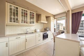 <p><span>Op zoek naar een ruim, instapklaar appartement waar licht, comfort en een uitstekende ligging samenkomen? Dan zit je hier helemaal goed. Op de vierde verdieping van een verzorgd gebouw geniet je van een zonnige leefruimte, een zuidgericht terras, twee volwaardige slaapkamers en heel wat praktische extra's zoals airco, ingemaakte kasten en een optionele autostaanplaats. Bovendien woon je aan de gegeerde Luitenant Lippenslaan, tussen het Te Boelaerpark, het Rivierenhof en de stad.</span></p><p><span>Licht, ruimte & comfort</span></p><p><span>Met de lift bereik je het appartement op de vierde verdieping. Je komt binnen in een ruime inkomhal met een veiligheidsdeur, videofoon en grote ingemaakte kasten waar jassen, schoenen en andere spullen netjes uit het zicht verdwijnen.<br />De leefruimte van maar liefst ca. 34 m² baadt de hele dag in het licht dankzij de grote zuidgerichte raampartijen. De warme parketvloer, stijlvolle sierschouw en airco zorgen voor een gezellige sfeer. Hier heb je alle ruimte voor een comfortabele zithoek en een grote eettafel.<br />De open keuken sluit mooi aan op de leefruimte en is ingericht in een charmante landelijke stijl met beige kasten en een werkblad met natuursteenlook. Je beschikt over een inductiekookplaat, heteluchtoven, vaatwasser, dubbele inox spoelbak, grote koelkast, diepvries en heel wat kastruimte. Via de keuken stap je rechtstreeks het zonnige, zuidgerichte terras van 10 m² op. Dankzij de gunstige oriëntatie en de zonneluifel geniet je hier van 's morgens tot 's avonds van de zon.</span></p><p><span> </span></p><p><span>Comfortabel en praktisch wonen</span></p><p><span>Via de nachthal bereik je de twee slaapkamers, beide rustig gelegen aan de achterzijde van het gebouw. De master bedroom van ca. 18 m² beschikt over een volledige wand ingemaakte kasten met geïntegreerde dressing, terwijl de tweede slaapkamer perfect dienstdoet als kinderkamer, logeerkamer of bureau. Beide kamers zijn voorzien van een onderhoudsvriendelijke laminaatvloer en rolluiken.<br />De badkamer is compleet uitgerust met een ligbad met douchescherm, een breed lavabomeubel met dubbele kraan, spiegelkasten met verlichting, een tweede toilet en extra opbergkasten. Daarnaast is er nog een apart gastentoilet.<br />Ook aan bergruimte geen gebrek. Naast de vele ingemaakte kasten beschik je over een ruime, droge privatieve kelderberging van 3,5 m². De gemeenschappelijke fietsenstalling biedt een veilige plaats voor je fiets en wie dat wenst, kan de ondergrondse autostaanplaats afzonderlijk aankopen voor € 25.000.</span></p><p><span> </span></p><p><span>Groen wonen met alles binnen handbereik</span></p><p><span>De Luitenant Lippenslaan is al jaren een van de meest gegeerde lanen van Deurne-Zuid. Op enkele minuten wandelen sta je in het Te Boelaerpark of het Boekenbergpark met zijn ecologische zwemvijver. Ook het Rivierenhof ligt vlakbij en biedt alle ruimte om te wandelen, sporten, fietsen of een zomerse voorstelling in het openluchttheater mee te pikken.<br />Voor je dagelijkse boodschappen liggen Delhaize, Colruyt, Lidl en tal van lokale handelaars vlakbij. Ook scholen, sportclubs en gezellige horecazaken bevinden zich in de onmiddellijke omgeving. Dankzij de tram, bus, de Singel en de Ring ben je altijd vlot onderweg. De combinatie van groen, bereikbaarheid en een aangename residentiële sfeer maakt deze buurt bijzonder geliefd.</span></p><p><span> </span></p>