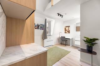 Op een uitzonderlijke ligging in het historische centrum van Leuven, in een zijstraat van de Naamsestraat en van de Oude Markt, bevindt zich deze kwalitatief afgewerkte duplex studentenkamer in Residentie Estelle. De kamer is gelegen op de derde verdieping aan de achterzijde van het gebouw en heeft een oppervlakte van ca. 15 m². De duplexindeling met mezzanine zorgt voor een aangename scheiding tussen de leef- en slaapruimte. Ze beschikt over een eigen badkamer met douche, lavabo en toilet en is daarnaast voorzien van een op maat gemaakte kledingkast en een praktisch ontbijtblok met koelkast en microgolfoven. De bewoners kunnen tevens gebruikmaken van een stijlvolle en volledig uitgeruste gemeenschappelijke keuken met onder meer een vaatwasser, diepvriezer en inductiekookplaat. Residentie Estelle combineert een karaktervolle, beschermde gevel met hedendaags wooncomfort en beschikt onder meer over ventilatiesysteem D met warmteterugwinning. De ligging vormt een absolute troef, midden in het Leuvense studenten- en stadscentrum, met verschillende KU Leuven-faculteiten, winkels, horeca en openbaar vervoer op wandelafstand. De kamer wordt momenteel verhuurd aan een netto huurprijs van €683,4 per maand en vormt daarmee een interessante investering in het centrum van Leuven. De verkoopprijs bedraagt €219.000. De verkoop valt onder het stelsel van de registratierechten.