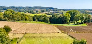 Grote degelijke woonst met bijgebouwen en hangar, een UNIEK ZICHT, op 4915m2.<br /><br />Waanzinnig uitzicht op de prachtige Vlaamse Ardennen. <br /><br />ZUIDGERICHTE tuin. <br /><br />Er is tevens een verkavelingsvergunning voor 3 loten: geen bouwverplichting. 2 bouwlagen + dak.