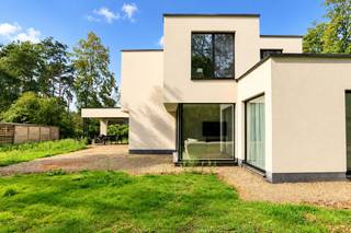 Licht, ruimte en groen lopen in deze uitzonderlijke BEN-nieuwbouwvilla haast vanzelf in elkaar over. Grote raampartijen, lange zichtlijnen en een bijzonder doordachte indeling zorgen ervoor dat de tuin vanuit vrijwel iedere leefruimte deel uitmaakt van het interieur. Gelegen in het groene Cambeenbos geniet u hier van een rustige residentiële woonomgeving, terwijl het centrum van Sint-Job, scholen en dagelijkse voorzieningen vlot bereikbaar blijven. Ook het kanaal en de omliggende natuur nodigen uit tot wandelen en fietsen, met belangrijke verbindingswegen richting Antwerpen binnen handbereik.<br /><br /><strong>Indeling</strong><br />De carport vormt architecturaal één geheel met de woning en wordt aangevuld met voldoende parkeergelegenheid op het perceel.<br /><br />Via de inkomhal met ruime vestiaire/polyvalente berging en gastentoilet ontstaat meteen een prachtig dieptezicht naar zowel de zij- als achtertuin. Dat sterke contact met buiten vormt de rode draad doorheen de volledige woning: overvloedig daglicht, open zichtlijnen en toch duidelijk afgebakende ruimtes zorgen voor een bijzonder aangename woonbeleving.<br /><br />Centraal bevindt zich de indrukwekkende, volledig op maat gemaakte leefkeuken, rechtstreeks verbonden met de eetruimte en het overdekte terras. Dankzij de elektrische lamellen kan dit terras naar wens volledig worden geopend of beschut en wordt het een natuurlijk verlengstuk van de leefruimte.<br /><br />Aansluitend aan de keuken bevinden zich een ruime berging en wasplaats met inloopdouche, gevolgd door de technische ruimte met afzonderlijke toegang langs de zijzijde van de villa.<br /><br />De eetruimte loopt natuurlijk over in de woonkamer, met daarnaast een afzonderlijke bureauruimte. Hoewel iedere ruimte een eigen functie en sfeer behoudt, staan ze voortdurend met elkaar in contact. De onderhoudsvriendelijke keramische parkettegel die over het volledige gelijkvloers werd doorgetrokken, versterkt die visuele rust en eenheid.<br /><br /><strong>Verdieping</strong><br />Op de eerste verdieping bevinden zich vier volwaardige slaapkamers. De master bedroom beschikt over een ensuite dressing en eigen badkamer, met voorzieningen voor een inloopdouche, ligbad en dubbele lavabo, deze dient men nog verder af te werken.<br /><br />Daarnaast is er een tweede badkamer met inloopdouche en dubbele lavabo, evenals een afzonderlijk toilet.<br /><br /><strong>Bijzonderheden</strong><br />Met E-peil 1 en EPC A, vloerverwarming via warmtepomp en 16 zonnepanelen werd deze villa ontworpen met een uitgesproken focus op energiezuinig en toekomstgericht wonen.<br />Verkoop onder registratierechten.