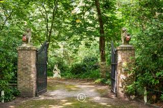 In de Zilverkust van Lanaken ligt dit karaktervolle landgoed, verscholen op een groen en bebost domein van ca. 2,4 hectare. Het landhuis dateert uit het interbellum en heeft een vloeroppervlakte van 996 m².<br /> <br />Het landhuis telt veel grote ruimtes, verspreid over het gelijkvloers en de twee verdiepingen. Daardoor zijn er heel wat mogelijkheden om de indeling aan te passen aan het toekomstige gebruik. Ook de kelder biedt veel plaats voor opslag en technische voorzieningen.<br /><br />Verschillende oorspronkelijke elementen bleven behouden, waaronder rode tegelvloeren, houten vloeren en parket, balkenplafonds, lambriseringen, ingebouwde kasten, glas-in-loodramen en verschillende schouwen. De grote ramen bieden zicht op het omliggende groen.<br /><br />Aan de woning liggen verschillende terrassen en een omsloten binnenplaats met fontein, rondbogen en een toren. Verder omvat het domein verschillende bijgebouwen.<br /><br />De ligging in de Zilverkust combineert rust, privacy en een groene omgeving met een vlotte verbinding naar Maastricht en de omliggende regio.