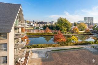 Élégant appartement duplex à vendre avec une vue magnifique sur le Petit Bassin à Roeselare.Cet appartement est situé au quatrième étage d'un élégant immeuble de 2008, près du parc Moerman à Roulers. Le design a été conçu par le célèbre cabinet d'architecture Buro II.Depuis le salon et les terrasses, vous pourrez profiter d'une vue magnifique sur le Petit Bassin, où l'eau, la verdure et la vie urbaine se marient harmonieusement.En 2018, l'appartement a été entièrement rénové par un architecte d'intérieur, en prêtant attention à la lumière, à l'espace et à un confort de vie de haute qualité. Le résultat est un intérieur contemporain et chaleureux où fonctionnalité et style se renforcent mutuellement.En entrant, le hall d'entrée spacieux vous accueille avec un vestiaire, des toilettes invités et un espace de bureau pratique, idéal pour travailler à domicile. Le salon lumineux avec de grandes fenêtres s'intègre parfaitement à la salle à manger et à la cuisine moderne entièrement équipée avec débarras/buanderie attenant. À ce niveau, il y a trois terrasses, chacune avec sa propre orientation, sa propre vue et son atmosphère, vous permettant de profiter du plein air à tout moment de la journée.À l'étage supérieur, vous trouverez deux chambres spacieuses et une troisième pièce qui peut être aménagée de manière flexible en chambre d'enfant, dressing ou bureau supplémentaire. L'élégante salle de bains comprend une baignoire, une douche à l'italienne, une deuxième toilette et une double vasque.L'appartement dispose également d'un spacieux débarras au sous-sol. Un box de garage souterrain peut être acheté en plus, avec la possibilité d'acheter même un deuxième box de garage. Les avantages en un coup d'œil :- Surface habitable considérable : 157 m²- 3 terrasses- Rangement spacieux au sous-sol inclus- Possibilité d'acheter un ou deux box de garage- Prêt à emménager et économe en énergie (EPC B /111 kWh/m²/an, aucune exigence de rénovation)- Emplacement central mais calme près du parc Moerman et du centre-ville de Roeselare