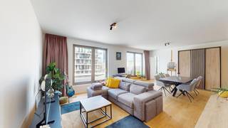 <p>L’espace de vie constitue le cœur de l’appartement et bénéficie d’une abondante lumière naturelle grâce aux grandes baies vitrées. Il offre suffisamment d’espace pour aménager à la fois un salon confortable et une généreuse salle à manger. La cuisine ouverte s’intègre harmonieusement à la pièce de vie et présente une finition épurée avec des armoires blanches, des appareils électroménagers intégrés et de nombreux rangements.<span></span></p>
<p>Depuis la pièce de vie, vous accédez directement à la spacieuse terrasse. Sa situation au dernier étage garantit davantage d’intimité ainsi qu’une vue dégagée sur l’architecture environnante.</p>
<p>La chambre, située au calme, dispose d’une salle de bains attenante équipée d’un meuble à double vasque, d’armoires de toilette avec miroir et d’une douche. L’appartement comprend également un débarras pratique ainsi qu’un WC séparé avec lave-mains.</p>
<p>L’abondance de lumière naturelle, l’agencement bien pensé, la généreuse terrasse et la situation au dernier étage font de cet appartement un lieu de vie particulièrement agréable.</p>