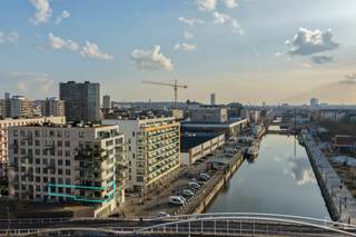 Op een toplocatie langs het kanaal, recht tegenover Tour & Taxis, bevindt zich dit stijlvolle en recente appartement (bouwjaar 2018) op de 2de verdieping. Vanuit het appartement geniet u van een prachtig open zicht over het water, terwijl u tegelijk vlakbij parken, gezellige horeca en vlotte verbindingen naar het centrum woont.<br /><br />Het appartement beschikt over een lichtrijke leefruimte met massieve parketvloeren die doorlopen in de hal en de drie volwaardige slaapkamers. Aansluitend bevindt zich een ruim westgericht terras van 28 m², ideaal om te genieten van de avondzon en het uitzicht op het kanaal.<br /><br />De open, volledig uitgeruste keuken is voorzien van kwalitatieve Siemens-toestellen, waaronder een inductiekookplaat, en sluit naadloos aan op de leefruimte.<br />Verder omvat het appartement drie volwaardige slaapkamers, een volledig betegelde badkamer en een aparte doucheruimte. Dankzij het ventilatiesysteem D en het gunstige PEB B-label geniet u van een energiezuinige en comfortabele woonomgeving. <br /><br />Een autostaanplaats is inbegrepen in de huurprijs. Daarnaast geldt een maandelijkse provisie van €120, inclusief gas. Elektriciteit en water zijn apart ten laste van de huurder.<br />Kortom, een modern en energiezuinig appartement op een uitstekende locatie in Brussel, waar ruimte, comfort en een uniek uitzicht samenkomen.<br /><br />Interesse? Neem contact met ons op voor meer informatie of een bezoek ter plaatse.