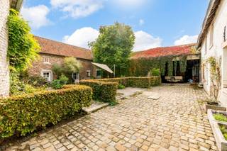 Ontdek de charme van deze historische hoeve met moderne luxe en comfort gelegen in de dorpskern van Rutten, midden in de natuur, nabij het bruisende centrum van Tongeren. <br />Deze unieke hoeve, daterend uit de 18e eeuw, biedt een uitstekende mix van authentieke elementen en hedendaags comfort. Momenteel in gebruik als een zeer gewaardeerde B&B, biedt dit pand een scala aan mogelijkheden voor de nieuwe eigenaar.<br /><br />Het hoofdgebouw en linkervleugel van de hoeve is recentelijk gerenoveerd met behoud van zijn authentiek karakter en aandacht voor kwalitatieve materialen en duurzame technieken. <br />De rechtervleugel is reeds structureel gerenoveerd en heeft nog verdere afwerking nodig. Deze kan naar eigen behoeften en wensen worden ingericht als extra studio, vakantiewoningen, ruimte voor vrij beroep,… <br />Daarnaast bieden de overige schuurgebouwen eveneens tal van mogelijkheden als opslagruimte, vergaderzaal, ruimte voor workshops,… Plannen en voorontwerpen voor de nog af te werken ruimtes, alsook voor de tuin zijn reeds beschikbaar.<br /><br />Het met veel zorg gerenoveerde deel van de hoeve herbergt momenteel een privéwoning en twee charmante vakantiewoningen. <br />De vakantiewoningen bevinden zich in de linkervleugel en hebben elk een eigen toegang, keuken, sanitair en bieden elk slaapgelegenheid aan 4 gasten. <br /><br />INDELING:<br />De privéwoning bevindt zich in het hoofdgebouw, links van de inrijpoort: <br />x Sfeervolle inkomhal met toegang tot de binnentuin en de gewelfde kelders en keuken; <br />x Links een lichtrijke leefruimte met salon en naastgelegen eetkamer met centraal een houthaard en achteraan een aparte hal met gastentoilet; <br />x Rechts een ruime leefkeuken met natuurstenen afwerking en volledig ingericht; <br />x Op de verdieping 4 slaapkamers en 2 uitgeruste badkamers waarvan één en-suitebadkamer gelegen aan de masterbedroom. Verder is er nog toegang tot een ruime bergzolder.<br /><br />De vakantiewoningen bevinden zich in de linkervleugel:<br />x De eerste vakantiewoning is bereikbaar vanuit de binnentuin en heeft contact met de authentieke binnenplaats. Gelijkvloers met keuken en zitruimte, op de verdieping 2 slaapkamers, badkamer met douche en toilet en nog een tweede apart toilet. <br />x De tweede vakantiewoning is bereikbaar vanuit de binnentuin via een charmante doorgang naar de ruime achtertuin en heeft een privaat terras. Deze gastenkamer bestaat uit een zithoek, slaapgedeelte en open mezzanine met extra slaapgelegenheid, badkamer met inloopdouche en toilet.<br />Overige ruimtes in de rechtervleugel en de schuurgebouwen zijn naar eigen wens in te richten en af te werken.<br /><br />De hoeve is opgenomen op de inventaris van het onroerend erfgoed en beschikt over een prachtige voorgevel. De stadscentrum van Tongeren ligt op slechts 4 km; steden zoals Maastricht, Luik, Hasselt en Sint-Truiden zijn vlot bereikbaar, met een strategische ligging ten opzichte van de snelwegen E313, E25 en E40. <br />Ervaar de perfecte mix van historisch karakter en moderne mogelijkheden in deze unieke hoeve. <br /><br />Neem vandaag nog contact met ons op om een bezichtiging te plannen en laat je inspireren door de ongekende mogelijkheden die dit bijzondere pand te bieden heeft.<br /><br />INTERESSE? Maak telefonisch een afspraak voor bezichtiging op het nummer 012 23 00 23 of mail uw vragen aan roland@immo-leroi.be.
