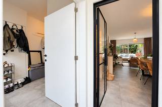 Deze verzorgde en smaakvol ingerichte woning is gelegen aan de Essenhoutstraat in Kapellen, op korte afstand van winkels, scholen en andere voorzieningen. De woning combineert een praktische indeling met een warme, hedendaagse afwerking.

Via de inkomhal kom je binnen in de ruime leef- en eetkamer met open keuken. De keuken is voorzien van een inductiekookplaat, dampkap, oven en voldoende kastruimte. Dankzij de grote schuiframen aan de achterzijde geniet de leefruimte van veel natuurlijk licht en een mooi zicht op de tuin. 

Op het gelijkvloers bevinden zich verder een apart gastentoilet en een praktische berging met toegang tot de overdekte zij-ingang, ideaal voor fietsen en extra opslagruimte.

Op de eerste verdieping bevinden zich drie slaapkamers en een ruime badkamer, uitgerust met een ligbad, inloopdouche en dubbele lavabo.

Een aparte, vaste betonnen trap leidt naar de bovenste verdieping. Hier bevinden zich een ruime master bedroom met zichtbare houten balken en een aansluitende dressing. Een fijne, afzonderlijke verdieping met de nodige privacy.

Ook buiten is het aangenaam vertoeven. De gezellige, onderhoudsvriendelijke tuin beschikt over een ruim terras, een houten loungeplatform en verschillende zitmogelijkheden. 
Dankzij de groene omheining geniet je hier van de nodige privacy.

Een instapklare woning met een aangename indeling, drie slaapkamers, ruime dressing en een gezellige buitenruimte, gelegen op een centrale locatie in Kapellen.

Wenst u meer informatie of een bezichtiging? Contacteer ons via 03 568 03 03 of tom@vastgoed03.be.
