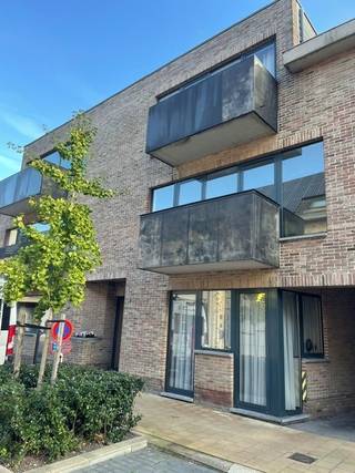 Het appartement omvat volgende ruimtes: Inkomhal, afzonderlijk toilet, ruime woonkamer met open ingerichte keuken, berging, 3 slaapkamers, ingerichte badkamer, ruim terras achteraan, garage nr. 16, en elektrische verwarming.