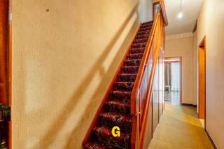Met een bruikbare oppervlakte van maar liefst 293 m² biedt deze halfopen woning heel wat mogelijkheden voor wie op zoek is naar ruimte en een eigendom dat volledig naar eigen wensen kan worden ingericht. De woning bevindt zich langs de Groenstraat, op een perceel van 544 m², op korte afstand van zowel Hoeselt als Bilzen en met een vlotte aansluiting op de E313 richting Hasselt, Tongeren en Maastricht.<br /><br />Het gebouw deed jarenlang dienst als gekende slagerij. Die vroegere bestemming is vandaag nog merkbaar in de praktische indeling, waarbij de voormalige handelsruimte aan de straatzijde tal van mogelijkheden biedt. Ze kan opnieuw worden ingericht voor een zelfstandige activiteit, een vrij beroep of een ruime thuiswerkplek. Uiteraard kan het volledige gebouw ook perfect worden ingericht als ruime gezinswoning.<br /><br />Hoewel een grondige renovatie zich opdringt, vormt de degelijke basis een belangrijk uitgangspunt. De dakconstructie verkeert in goede staat en ook de elektrische installatie werd reeds aangepast, waarvoor een conformiteitsattest beschikbaar is. De ruime volumes laten bovendien toe om de woning volledig volgens de eigen woonwensen in te delen.<br /><br /><br />Indeling<br /><br />Gelijkvloers<br />De voormalige handelsruimte bevindt zich aan de voorzijde van het gebouw en sluit aan op de centrale hal. Verder omvat het gelijkvloers een zitruimte, een ruime kamer die zich uitstekend leent voor de inrichting van een open leefkeuken, een achterbouw met de huidige keuken, sanitaire voorzieningen en badkamer, een inpandige garage en de trap naar zowel de verdieping als de droge kelder.<br /><br />Verdieping<br />De eerste verdieping beschikt over drie volwaardige slaapkamers en een badkamer met douche en toilet. Vanuit de nachthal leidt een vaste trap naar de zolder.<br /><br />Zolder<br />De ruime zolderverdieping beschikt over een betonnen vloer en een degelijke dakconstructie. Hierdoor biedt deze verdieping interessante mogelijkheden voor bijkomende woonruimte, slaapkamers of een hobbyruimte.<br /><br />Buiten<br />Achter de woning ligt een volledig omheinde tuin met terras, waar voldoende ruimte is om een aangename buitenomgeving te creëren.<br /><br />Technische gegevens<br />-Bruikbare oppervlakte: 293 m²<br />-Perceeloppervlakte: 544 m²<br />-EPC: Label F – 804 kWh/m² per jaar<br />-Renovatieverplichting van toepassing<br />-Elektrische installatie conform<br />-Degelijke dakstructuur<br />-Droge kelder<br />-Inpandige garage<br /><br />Deze eigendom richt zich in het bijzonder tot kandidaten die op zoek zijn naar een ruim renovatieproject met veel potentieel. Dankzij de royale oppervlakte en de voormalige handelsruimte zijn uiteenlopende invullingen mogelijk, gaande van een ruime gezinswoning tot de combinatie van wonen en werken, afhankelijk van de eigen plannen en wensen. <br /><br />Een bezoek geeft pas echt een goed beeld van de ruimte en de mogelijkheden die dit eigendom te bieden heeft.