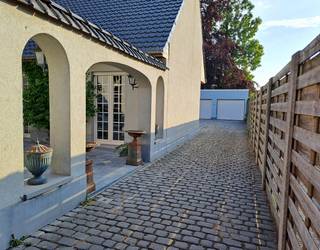 <p>Deze woning ligt in een rustige eenrichtingsstraat, met alle gemeentelijke faciliteiten — winkels, scholen, bibliotheek, academie, openbaar vervoer en het station — op wandelafstand. Je woont hier in het centrum, maar toch in een stille straat, met bovendien een vlotte bereikbaarheid dankzij de gewestweg richting Knokke en de E40, zonder hiervan geluidshinder te ondervinden.</p><p>Binnenin ontdek je een verrassend ruime en lichtrijke woning met flexibele indelingsmogelijkheden. De leefruimtes voelen warm en open aan, en dankzij de twee badkamers en verschillende kamers die je naar wens kunt invullen, groeit dit huis moeiteloos mee met elke levensfase. Groter wordende kinderen krijgen hier hun eigen plek en privacy, terwijl de woning zich net zo goed leent voor het mee‑inwonen van ouder wordende ouders. Daarnaast bieden de extra leefruimtes — vandaag ingericht als livings — een uitstekende kans om een vrij beroep uit te oefenen. Ze kunnen perfect dienen als praktijkruimte, kantoor, ontvangstruimte of zelfs als plek om een uit de hand gelopen hobby onder te brengen, volledig afgescheiden van het privé‑gedeelte.</p><p>Het voorhuis is opgetrokken tussen 1914 en 1918, deze woning kende de grootste renovatie in 2006, waarbij de volledig woning onder handen genomen werd en een nieuwe woonunit aanpalend aan de woning werd bijgebouwd.</p><p>Midden in de woning bevindt zich een gezellige patio: een intieme buitenplek waar je ’s morgens rustig kunt ontbijten, een koffietje drinken of je even terugtrekken met een boek. Deze beschutte hoek brengt een heerlijk gevoel van rust en maakt het buitenleven extra toegankelijk.</p><p>De grote, volwassen tuin vormt een groene, rustige plek waar je kunt genieten van schaduw, ruimte voor dieren of gewoon de buitenlucht. Een dubbele gesloten garage, en de praktische kelder, zorgt voor opbergcomfort. Alles samen maakt dit huis tot een warme, comfortabele en verzorgde thuisbasis in het hart van Aalter.</p>