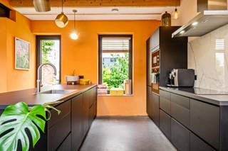 Dit unieke achterhuis is een zeldzame vondst: verborgen in alle rust, midden in de stad, volledig gerenoveerd en met een uitstraling waar Pinterest spontaan zenuwachtig van wordt.<br /><br />Vanop straat heb je geen idee wat zich achter de poort schuilhoudt. En dat maakt het net zo bijzonder. Achteraan het perceel ontdek je een verrassend rustige woonplek, volledig gerenoveerd in 2022 met een indrukwekkend gevoel voor stijl, warmte en slimme keuzes.<br />En het mooie? Het ziet er niet alleen goed uit, het zit ook technisch helemaal juist. Dankzij de grondige renovatie geniet je hier van een uitzonderlijk gunstig EPC A met E-peil E51, conforme elektriciteit, dakisolatie, vloerverwarming, airco en zonnescreens.<br />Een woning waar even hard aan comfort gedacht werd als aan esthetiek.<br /><br />Het gelijkvloers is zonder twijfel het pronkstuk van het huis. De leefruimte baadt in licht dankzij indrukwekkende ramen voor-en achteraan. De hoge plafonds, warme houten balken en stalen accenten zorgen voor een loftvibe. <br />De strakke zwarte keuken met royaal kookeiland op betonnen vloer vormt het kloppende hart van de woning. Een plek waar gasten automatisch blijven hangen “voor nog eentje” en waar elke zondagmorgen net iets trager mag verlopen.<br /><br />En dan de buitenruimtes, meervoud, want dit huis verwent je driemaal!<br />Het intieme koertje grenst direct aan de leefruimte: de plek voor je ochtendkoffie of gewoon even niets. Dan een verrassend groene tuin achteraan waar de stad plots héél ver weg lijkt, weelderig begroeid met klimplanten langs de oude bakstenen muren. En vooraan nog een extra terras waar stad en rust elkaar subtiel ontmoeten.<br /><br />Op de eerste verdieping bevinden zich twee slaapkamers, een apart toilet en een badkamer waar wellnessgevoel en design perfect samenkomen. Een vrijstaand bad, ruime inloopdouche en dubbele lavabo maken van deze ruimte een plek waar “ik neem snel een douche” opvallend vaak eindigt in een uur verdwijnen van de wereld.<br />De tweede verdieping telt nog twee extra kamers, waaronder een prachtige master bedroom met handige lavabo en extra kastruimte.<br /><br />Ook praktisch scoort deze woning moeiteloos punten. Er is een handige kelder voor extra opslagruimte en via de gedeelde toegangspoort parkeer je superhandig je (bak)fietsen.<br /><br />Een woning als deze laat zich moeilijk in vakjes stoppen. Te warm om strak te zijn. Te stijlvol om gezelligheid te verliezen. En vooral: veel te bijzonder om onopgemerkt te blijven.<br /><br />Troeven: <br />– Volledig & stijlvol gerenoveerd achterhuis <br />– 4 kamers <br />– Uitzonderlijk veel lichtinval <br />– Spectaculaire open leefruimte met blootgelegde balken <br />– Designkeuken met kookeiland <br />– Luxueuze badkamer met vrijstaand bad & inloopdouche <br />– 3 buitenruimtes: Koertje, weelderige tuin en terras <br />– Rustig gelegen en toch in hartje 2060<br />- Vraagprijs is richtprijs<br /><br />Wg, Gvkr, Gvv, Gmo, geen overstrominsgevoelig gebied