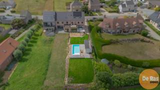 OTTERGEM – Deze adembenemende nieuwbouwwoning combineert tijdloze elegantie met state-of-the-art technieken. Tot in de puntjes afgewerkt met oog voor detail, biedt deze villa een instapklare woonervaring die luxe, comfort en functionaliteit harmonieus samenbrengt.<br /><br />Bij binnenkomst trekt de pivoterende deur meteen de aandacht – een architecturaal statement dat de toon zet voor de rest van de woning. De leefruimte baadt in natuurlijk licht en werd verfijnd afgewerkt met warme parketvloeren, een gezellige gashaard en grote raampartijen. Vloerverwarming zorgt overal voor aangename warmte en ultiem comfort. <br />De leefkeuken vormt het hart van de woning: een modern kookeiland met geïntegreerde wijnkoelkast en alle hedendaagse toestellen. Terwijl u kookt geniet u van een prachtig zicht op de tuin – een setting die uitnodigt tot culinair genieten én gezellige momenten met familie of vrienden.<br />De woning beschikt over 4 ruime slaapkamers, waaronder een luxueuze master suite met dressing, en 2 elegante badkamers die zijn ingericht met hoogwaardige materialen (mortex). <br />Voor wie thuiswerkt is er een aparte bureauruimte, afgezonderd van de leefruimte voor optimale rust.<br />Technisch is deze woning volledig futureproof. Een warmtepomp in combinatie met airco garandeert een perfect binnenklimaat in elk seizoen. Dankzij de aanwezigheid van zonnepanelen en een uitzonderlijk E-peil van slechts 2, geniet u van extreem lage energiekosten en draagt u bij aan een duurzame toekomst.<br />De woning is bovendien volledig onderkelderd, wat tal van mogelijkheden biedt: een fitnessruimte, hobbykamer, wijnkelder of extra bergruimte. Buiten wacht een oase van ontspanning met een zwembad, zonnig terras en een elegant poolhouse.<br /><br />Bovendien geniet u hier van een centrale ligging: scholen, winkels en belangrijke verbindingswegen bevinden zich op korte afstand. <br /><br />Mis deze unieke kans niet om te wonen in een woning waar luxe, comfort en duurzaamheid hand in hand gaan.<br /><br />Info en bezoek via kantoor: 053/60.65.60