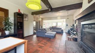 Bij ImmoFusion 7/7 “open huis” : klik op onze 3D-TOUR.<br />Ervaar vastgoed alsof je er zelf doorloopt!<br /><br />Stap binnen in deze bijzonder ruime woning, gelegen aan de Kortenbosstraat 1 in Sint-Truiden. Met maar liefst 6 slaapkamers, een inpandige garage, een ruime landelijke keuken, een bijzonder grote leefruimte en een perceel van maar liefst 36a 70ca biedt deze eigendom een uitzonderlijke hoeveelheid ruimte en mogelijkheden. De combinatie van het ruime perceel, de aanwezige paardenstallen, fruitbomen, serre en het losstaande zwembad maakt dit bovendien een bijzonder interessante eigendom voor wie houdt van ruimte, groen en landelijk wonen.<br /><br />Bij binnenkomst word je verwelkomd in de ruime inkomhal. Hier bevindt zich een gastentoilet en heb je meteen toegang tot verschillende ruimtes van de woning. Aan de rechterzijde van de inkomhal vinden we de living, terwijl je rechtdoor verdergaat richting de keuken. De houten balken in de woning zorgen hierbij voor een karaktervolle uitstraling en vormen een mooie structurele toets doorheen het geheel.<br /><br />De woning beschikt over een enorme woonkamer waar ruimte en gezelligheid centraal staan. De aanwezige pelletkachel en inbouwhaard zorgen tijdens de koudere maanden voor extra warmte en sfeer.<br /><br />Centraal in de woning vinden we de leuke, nieuwe landelijke keuken. Deze vormt een aangename verbinding tussen de verschillende leefruimtes en biedt dankzij haar ligging een bijzonder praktische basis voor het dagelijkse gezinsleven. Vanuit de keuken kan je eveneens naar de ruime living en woonkamer.<br /><br />Op het gelijkvloers bevindt zich verder de badkamer, uitgerust met een douche, bad, toilet en lavabo. Een extra troef is dat de badkamer via twee afzonderlijke deuren bereikbaar is, wat zorgt voor een praktische circulatie binnen de woning.<br /><br />Vanuit de gang bereik je eveneens de eerste twee slaapkamers, de berging/wasplaats en de inpandige garage. De garage zorgt niet alleen voor een veilige plaats voor de wagen, maar biedt dankzij de rechtstreekse aansluiting met de woning ook extra comfort in het dagelijkse gebruik.<br /><br />Op de bovenverdieping bevinden zich nog vier bijkomende kamers. Deze ruimtes kunnen, afhankelijk van de noden van de nieuwe bewoners, ingericht worden als slaapkamers, hobbykamers, bureau, speelruimte of dressing. Hierdoor beschikt de woning over maar liefst 6 slaapkamers en is er bijzonder veel flexibiliteit voor een groot gezin, thuiswerkers of wie graag extra ruimte ter beschikking heeft. Op deze verdieping is bovendien nog een afzonderlijk toilet aanwezig.<br /><br />Ook buiten heeft deze eigendom heel wat te bieden. Het perceel is maar liefst 36a 70ca groot en biedt hierdoor een zee aan ruimte. Momenteel zijn er paarden aanwezig en op het perceel bevinden zich 2 paardenstallen en een opslagplaats voor hooi, waardoor de woning bijzonder interessant is voor paardenliefhebbers of wie droomt van een eigen plek voor dieren.<br /><br />Verspreid over het perceel zijn eveneens fruitbomen aanwezig en er is een serre voorzien, ideaal voor wie graag zelf groenten, kruiden of andere gewassen kweekt. Daarnaast staat er momenteel een losstaand zwembad dat eventueel kan blijven staan en tijdens de zomermaanden voor de nodige ontspanning kan zorgen.<br /><br />Pluspunten:<br />- Ruime woning met maar liefst 6 slaapkamers<br />- Perceel van maar liefst 36a 70ca<br />- Zeer grote woonkamer<br />- Leuke, nieuwe landelijke keuken<br />- Badkamer op het gelijkvloers<br />- Inpandige garage<br />- Karaktervolle houten balken<br />- 17 zonnepanelen<br />- Paardenstallen aanwezig<br />- Losstaand zwembad dat kan blijven staan<br />- Zeer ruime buitenomgeving met tal van mogelijkheden<br />- Landelijke uitstraling<br /><br />Voor een bezichtiging ter plaatse of meer info, bel ons op 078/78.78.70, of kom gewoon binnen op ons kantoor, steeds welkom!