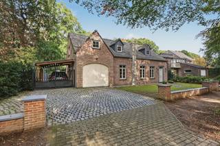 Heerlijk wonen met zicht op blijvend groen. Zo kan je kort samenvatten wat wonen in deze volledig gerenoveerde woning inhoudt.<br />In 2013 werd deze woning op enkele muren na volledig vernieuwd en werd er gekozen voor duurzame en kwalitatieve materialen. Dit maakt dat de woning dan ook instapklaar is. De aantrekkelijke voorgevel nodigt je meteen ook uit om de woning verder te ontdekken.<br /><br />Vanuit de ruime inkomhal met vestiaire en gastentoilet kom je in de leefruimte. Deze bestaat uit twee delen, een zithoek op een massieve en originele parket met houtkachel met rondom een imposante schouw. De eetkamer gaat dan weer naadloos over in de open keuken waar het heerlijk koken is met zicht op de tuin. De keuken zelf is volledig geïnstalleerd en voorzien van gasvuur, vaatwasser, oven, combi-oven en ingebouwde koelkast. Vanuit de leefruimte kan je eveneens naar een ruimte welke momenteel is ingericht als bureau maar eveneens kan dienen als slaapkamer op het gelijkvloers én bovendien een eigen douchekamer heeft. Het grote raam met open zicht op de tuin en achterliggend bos zorgt dan ook voor instant rustgevoel. Deze ruimte met de keuken en eetkamer genieten tevens van vloerverwarming. <br /><br />Op het verdiep welke geniet van een nachthal met ingemaakte kasten vinden we een eerste kamer terug welke kan dienen als bureau of dressing, een eerste slaapkamer en badkamer voorzien van ligbad, inloopdouche, dubbel wasmeubel en toilet. Op het einde van de nachthal kom je in de masterbedroom welke tot in de nok opengemaakt is. <br /><br />Terug op het gelijkvloers vinden we nog een ruime garage terug met automatische poort waar ook alle nutsvoorzieningen binnenkomen. Vanuit de garage kan je tevens ook makkelijk naar het terras op een blauwe steen. <br /><br />De tuin welke grenst aan een prachtig parkdomein zorgt ervoor dat je heerlijk kan gieten van de rust en het groen. In de tuin is er eveneens een eiken tuinhuis als een tweede tuinhuis met diverse mogelijkheden. Momenteel ingericht als garage maar kan perfect omgevormd worden tot poolhouse of andere ruimte. <br />Naast de woning is er tevens nog een kwalitatieve eiken carport voorzien. <br /><br />Met andere woorden een instapklare woning met verschillende pluspunten. Maak een afspraak en laat de woning zelf u overtuigen.