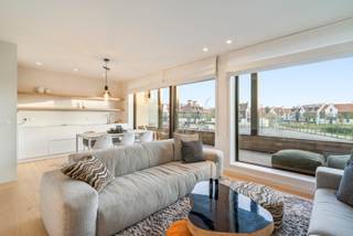 Sunny corner apartment with two bedrooms in Duinenwater – prime location near the beach and town center<br />This stylish, move-in-ready corner apartment is located in the heart of Duinenwater, a vibrant and rapidly growing area in Knokke. Enjoy peaceful living with all the city’s highlights just a short walk away: the beach, the promenade, and the lively shopping district. All amenities, leisure options, and public transport are within easy reach.<br />Layout:<br />The entrance hall with cloakroom leads into the bright living area with a fully equipped open kitchen and dining space. From the living room, you have direct access to the south-facing terrace – the perfect spot to enjoy the sun. The apartment offers two spacious bedrooms and a sleek bathroom with walk-in shower, double sink, and toilet. There’s also a separate guest toilet and a utility room with connections for a washer and dryer.<br />The residence includes a bicycle storage room and waste disposal area.<br />Optional: possibility to purchase two adjacent parking spaces in the underground garage (-1).<br /><br />For more information or a site visit, please contact Tine Vandenberghe: T: 0497 53 45 29 or info@Tine.immo