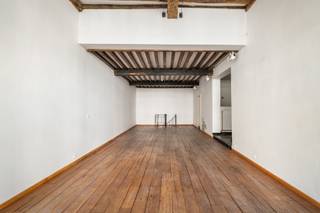 Situé dans la Keizerstraat, au cœur historique d’Anvers, ce rez-de-chaussée commercial de caractère offre une superficie d’environ 150 m². Sa situation centrale, combinée à son accessibilité aisée par les Leien et les transports en commun à proximité, constitue un atout majeur.
L’espace se distingue par son caractère authentique et son agencement ouvert. La façade imposante et les grandes baies vitrées lui confèrent une allure attrayante ainsi qu’une agréable luminosité naturelle. À l’intérieur, le plancher en bois et la structure apparente des poutres créent une atmosphère chaleureuse et pleine de caractère.
Grâce à son plan rectangulaire bien structuré, le bien offre diverses possibilités d’aménagement et d’utilisation. Il convient notamment pour un bureau, un espace de pratique professionnelle, une profession libérale, une galerie ou toute autre activité commerciale.
Un atout supplémentaire réside dans le sous-sol, agrémenté de voûtes en briques authentiques et d’un sol carrelé. Cet espace de caractère peut être utilisé de manière flexible comme espace de stockage, salle de réunion ou espace professionnel ou de travail supplémentaire.
Un sanitaire et une kitchenette sont présents. D’éventuels aménagements du bien peuvent être discutés avec le propriétaire, en fonction de l’affectation envisagée.
La provision mensuelle pour l’eau, le gaz et le précompte immobilier s’élève à 275 €. L’électricité doit être souscrite séparément et individuellement par le locataire.