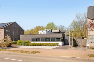 Deze bijzondere gelijkvloerse villa combineert hedendaags comfort met een prachtige natuurlijke omgeving. Deze eigendom wordt gekenmerkt door grote glaspartijen, een hoogwaardige afwerking en een unieke architectuur.<br />Door het achterliggende natuurgebied, dat rechtstreeks via de tuin toegankelijk is, is het zowel binnen als buiten heerlijk vertoeven.<br /><br />Deze woning is volledig gelijkvloers voorzien waardoor het een ideale gezinswoning is maar ook uitermate geschikt voor kopers op leeftijd of mindervaliden.<br />De eigendom bestaat uit een lichtrijke woonkamer, half open keuken, 2 slaapkamers die omgevormd kunnen worden naar 3 slaapkamers, ruime badkamer, dressing, apart toilet, bergruimte, wasplaats, technische ruimte, aparte garage en multifunctioneel bijgebouw met overdekt terras.<br /><br />Indeling:<br />U betreedt de woning via een ruime inkomhal die voorzien is van een apart toilet en praktische bergruimte. De ruime en gezellige leefruimte met grote glaspartijen en een sfeervolle pelletkachel vloeit naadloos over in de recent vernieuwde, volledig uitgeruste keuken met uitzicht op de tuin.<br />Oorspronkelijk beschikte de woning over drie slaapkamers, waarvan er momenteel twee samengevoegd zijn tot een royale masterbedroom. Deze slaapkamer beschikt over een eigen dressing met op maat gemaakte kasten en een prachtige badkamer met ligbad, inloopdouche en hoogwaardig afgewerkt badkamermeubel.<br />Voorts bevindt er zich een praktische wasplaats/technische ruimte.<br /><br />Tuin:<br />De tuin biedt een oase van rust door zijn fraaie beplanting en uitzicht op het achterliggende natuurgebied. De tuin is volledig omheind en uitgerust met robotmaaier. Op het perceel bevindt er zich een aparte garage, alsook een multifunctioneel bijgebouw met kitchenette wat ideaal is als gastenverblijf of tuinbureau. Dit bijgebouw is bijkomstig voorzien van een overdekt terras waardoor het hier in ieder seizoen zalig vertoeven is.<br /><br />Bijzonderheden:<br />- Gelijkvloerse villa met rechtstreekse toegang tot natuurgebied<br />- Aparte geïsoleerde garage en multifunctioneel bijgebouw met kitchenette, airco en verwarming<br />- Ideale combinatie tussen het wonen aan de rand van de stad, vlakbij de fietsostrade met de rust van de natuur<br />- 2 slaapkamers mogelijk opnieuw om te bouwen naar 3 slaapkamers<br />- Hoogwaardige afwerking en zeer goed onderhouden eigendom <br />- Dak vernieuwd 4 jaar geleden<br />- Alarm