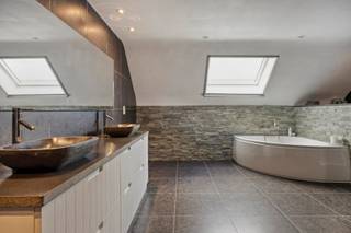 In het rustige en groene Affligem(rand Meldert) vind je deze 4-gevel woning met een tijdloze, en langs de straatzijde sobere uitstraling. Achter de gevel schuilt echter een verrassend ruime en moderne thuis die uitblinkt in comfort, licht en leefkwaliteit.
Dankzij het energiezuinige label A, 18 zonnepanelen, vloerverwarming en domotica leef je hier uiterst comfortabel én duurzaam. De zeer ruime leefruimte m. open keuken, 60m², m. gashaard als sfeerelement, baadt in een zee van licht owv de grote raampartijen. Aangrenzend bevindt zich de bergruimte met washoek met toegang tot de dubbele garage en de zijtuin. De bovenverdieping heeft 3 royale slaapkamers (15 m² + dressing, 32 m² en 32 m²). De luxe badkamer van 22m² beschikt over een inloopdouche, een hoekbad en een dubbel lavabomeubel. Voor wie 3 slaapkamers onvoldoende zijn kan de zolderverdieping nog verder ingericht worden tot 2 slaapkamers.
Buiten is het volop genieten: een zwembad, 3 zonnige terrassen en een ruime tuin met weids uitzicht maken dit een plek waar rust en privacy centraal staan.
Troeven op een rij:
4-gevelwoning
Mogelijkheid tot 5 slaapkamers
Zeer energiezuinig (label A)
18 zonnepanelen
Domotica & vloerverwarming
Zwembad en 3 terrassen
Grote tuin met prachtig open zicht
Landelijke, rustige ligging
Deze woning combineert landelijke rust met modern wooncomfort, ideaal voor wie ruimte en kwaliteit zoekt. Interesse? Dit is een unieke kans in een uitzonderlijke omgeving! Contacteer ons via affligem@immoaccenta.be.