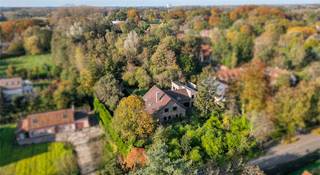 Deze villa, gelegen tussen de Leie en de Golf is ligt op een perceel van 5.089 m2 . Het perceel geniet van een zuidwestelijke oriëntatie, een eigen bos en een groot zwembad. De woning dateert van 1988 en heeft een bewoonbare oppervlakte van 528m2. Hierdoor biedt deze woning enorm veel potentieel.<br /><br />Het gelijkvloers is als volgt opgedeeld: inkomhal met gastentoilet, ruime bureauruimte, eventuele eerste slaapkamer. Grote, open leefruimte met veel lichtinval. Keuken met bijkeuken die toegang biedt tot de garage waar plaats is voor twee wagens en extra opbergruimte. Verder is er nog een praktische kelder.<br /><br />De eerste verdieping biedt plaats voor drie ruime slaapkamers en een badkamer. Daarnaast zorgt de grote polyvalente ruimte voor extra opportuniteiten.<br /><br />Naast de hoofdwoning is er tevens een bijwoning voorzien. U heeft toegang tot de bijwoning via een aparte inkomhal, maar ook via de garage en de polyvalente ruimte. De bijwoning heeft tevens een lift.<br /><br />Met al deze troeven biedt deze villa een uitzonderlijke woonervaring midden in de groene en exclusieve omgeving van Sint-Martens-Latem.