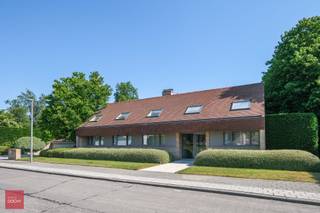 De villa bestaat uit een inkomhal met vestiaire en toilet, living in parket met open haard, open vernieuwde keuken palend aan zonnig terras, afzonderlijke eetruimte, ruime bijkeuken of wasberging, bureel, masterbedroom met dressing met ensuite badkamer, 4 overige slaapkamers, 2de badkamer alsook nog een afzonderlijke douchekamer, polyvalente ruimte of hobbykamer (momenteel bar), zolder, prachtig binnenzwembad met luchtcirculatie, automatische screens en rechtstreeks toegang tot de tuin, volledig onderkelderd (kleedkamers, sauna, doucheruimtes, voorraadkelder, centrale stofzuiger, CV-kelder en wijnkelder). Verder is er de zonnige tuin, verschillende terrassen en dubbele garage.<br />Vervolgens is er een 2de woonst (afzonderlijk huisnummer) zeer geschikt als kangoeroewoning/zorgwoning, kantoren of praktijkruimte, bestaande uit: inkomhal, bureel, wachtplaats, 2 ruime kantoren/kamers/praktijkruimtes, keuken, bergruimte en sanitair. Onnoemelijk veel mogelijkheden bvb voor nieuw samengesteld gezin of zorgwoning (ca 820m² bewoonbare oppervlakte), op wandelafstand van de Leieboorden en Kortrijk centrum! Aarzel niet ons te contacteren voor meer inlichtingen of een vrijblijvend bezoek ter plaatse.