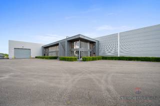 *** onder option***Het gebouw bestaat uit een opslagruimte van +/- 2.640 m² met een vrije hoogte van 8 m. Het is uitgerust met een rolbrug en...