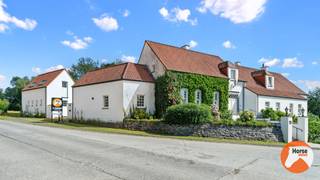 FRASNES - Exclusieve eigendom met 3 woonentiteiten en B&B<br /><br />In het rustige en landelijke Frasnes bevindt zich deze uitzonderlijke eigendom op een perceel van maar liefst 1,15 hectare. Met een bewoonbare oppervlakte van circa 830 m² combineert deze unieke woning royaal wooncomfort met tal van mogelijkheden voor werken, verhuren en ontspannen.<br /><br />De statige hoofdwoning beschikt over zes ruime slaapkamers, zes badkamers, twee volledig uitgeruste keukens en indrukwekkende leefruimtes die zich perfect lenen voor een groot gezin, een kangoeroewoning of een combinatie van wonen en een vrij beroep of praktijk.<br />Onder de hoofdwoning bevindt zich een volledig ingerichte, afzonderlijke woonunit. Daarnaast zorgen een garage, wijnkelder en praktische wasruimte voor extra comfort.<br /><br />De eigendom biedt bovendien een aantrekkelijk investeringspotentieel. Een gedeelte van de woning wordt momenteel succesvol verhuurd via Airbnb, terwijl twee kamers met eigen badkamer op jaarbasis worden verhuurd. Achteraan het domein bevindt zich een extra appartement met een aparte ingang, dat eveneens een mooi huurrendement genereert.<br /><br />Het naastgelegen bijgebouw biedt nog tal van extra mogelijkheden en kan perfect dienst doen als kantoor, praktijkruimte, gastenverblijf of vakantiewoning.<br /><br />Ook buiten is het volop genieten. De prachtig aangelegde tuin beschikt over een verwarmd zwembad met stijlvol poolhouse, een sfeervolle vijver, een boomgaard en uitgestrekte weides. Dankzij de royale perceeloppervlakte is deze eigendom bovendien bijzonder geschikt voor paardenliefhebbers of dierenhouders die hun hobby of activiteit aan huis willen combineren.<br /><br />Deze exclusieve eigendom onderscheidt zich door haar indrukwekkende volumes, kwalitatieve architectuur en uitzonderlijke flexibiliteit in gebruik. Een zeldzame opportuniteit voor wie op zoek is naar ruimte, privacy en een eigendom met ongekende mogelijkheden, op een centrale en vlot bereikbare ligging.<br /><br />Voor meer informatie of een bezoek, kan u ons steeds contacteren via 053/60.65.66.