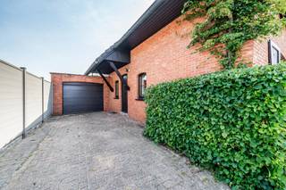 <p>Ruime gezinswoning met renovatiepotentieel op een mooi perceel. <br />Rustig gelegen in een aangename woonwijk, op korte afstand van het dorpscentrum.</p>
<p><strong>INDELING</strong></p>
<p><span>Gelijkvloers</span><br />De inkomhal vormt de centrale toegang tot de woning en leidt enerzijds naar de lichtrijke woonkamer met houtkachel en anderzijds naar de ruime leefkeuken.</p>
<p>De keuken is functioneel ingericht met een elektrisch kookvuur, dampkap en koelkast.</p>
<p>Vanuit de keuken zijn de kelder, de badkamer en het toilet bereikbaar.</p>
<p>Aansluitend bevindt zich een royaal overdekt terras, waar je geniet van het uitzicht op de achterliggende tuin.</p>
<p><span>Verdieping</span><br />Op de verdieping bevinden zich 4 volwaardige slaapkamers en een apart toilet.</p>
<p><span>Kelder/Zolder</span><br />De woning is deels onderkelderd en deels voorzien van een kruipkelder. <br />De zolder is bereikbaar via een vlizotrap.</p>
<p><span>Tuin</span><br />De tuin heeft een volwassen begroeiing dewelke zorgt voor een groen en natuurlijk kader, terwijl de tuin momenteel relatief weinig onderhoud vraagt. Achteraan bevindt zich een tuinberging en een serre.</p>
<p>Een garage voor 1 wagen is aangebouwd aan de woning.<br />Daarnaast biedt de oprit vlot plaats aan 2 extra wagens.</p>
<p>Kortom, een karaktervolle woning die klaar is voor renovatie, maar dankzij haar ruime vertrekken, aangename perceel en sterke ligging bijzonder veel mogelijkheden biedt.</p>
<p>BIJZONDERHEDEN<br />- houten schrijnwerk met handbediende houten luiken<br />- hoogrendementsglas (2018)<br />- verwarming op gas met condenserende ketel (2016)<br />- dak geïsoleerd (2020)<br />- elektriciteit niet conform<br />- EPC label E (406 kWh/m² jaar)</p>
<p>POSITIEVE ASPECTEN<br />- ruime en lichtrijke vertrekken<br />- tal van renovatie- en inrichtingsmogelijkheden<br />- rustig gelegen en toch vlak bij de dorpskern<br />- karaktervolle woning met veel potentieel</p>
<p><em>Stedenbouwkundige inlichtingen in aanvraag</em></p>