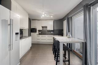 We betreden de woning via de inkomhal, die toegang biedt tot de gezellige leefruimte met inbouwhaard.Achteraan bevindt zich de vernieuwde keuken,...