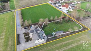 Met een bewoonbare oppervlakte van meer dan 350m² op een domein van bijna 10.000m² geniet je hier werkelijk van een zee van ruimte en zeer veel privacy.<br /> <br />We bereiken de woning via een brede oprijlaan. Voor de woning zijn verschillende parkeerplaatsen aangelegd.<br /><br />In de inkomhal vinden we een gastentoilet met lavabo, toegang tot de bureelruimte (ook via de woonkamer bereikbaar) en een dubbele glazen deur naar de woonkamer. De werkelijk zeer ruime, lichtrijke woon- en eetkamer met prachtige vergezichten rondom heeft een mooie open haard voor extra gezelligheid. De grote keuken is luxueus en compleet ingericht met alle toestellen en veel kastruimte, en heeft een directe toegang tot 2 praktische bergingen: via de ene berging bereiken we de droge kelder, via de andere berging komen we in de garage met elektrische poort waar gemakkelijk 2 wagens en verschillende fietsen kunnen staan.<br /> <br />Op de verdieping vinden we een afzonderlijk toilet, 3 ruime slaapkamers en een badkamer (lavabo en luxedouche). Eén van de slaapkamers heeft een dressing en een eigen badkamer (dubbele lavabo, bad, luxedouche en toilet). In elke slaapkamer is airco aanwezig. <br /><br />Er is een zolder aanwezig die bereikbaar is via een luik. <br /><br />In de prachtig aangelegde tuin met verschillende terrassen, bereikbaar vanuit zowel de leefruimte als de keuken, treffen we nog een serre en een groot tuinhuis. Palend aan de woning en de tuin is er een weide van meer dan 7700m² die mee in de verkoopprijs is inbegrepen.