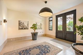 Uitzonderlijk villa-appartement van ca. 330 m²! <br />Een zeldzame combinatie van de ruimte en grandeur van een royale villa met het comfort, de privacy en het onderhoudsgemak van residentieel wonen. De statige architectuur, fraai aangelegde tuinen en hoogwaardige afwerking onderstrepen het exclusieve karakter van het geheel. Met zijn uitzonderlijke woonoppervlakte, royale buitenruimtes en bijzonder doordachte indeling, is dit appartement het absolute topsegment van Schilde.<br /><br />Indeling:<br />De privatieve inkomhal met vestiaire en toilet, vormt meteen een stijlvolle introductie en geeft via elegante stalen binnendeuren toegang tot de leefruimtes.<br /><br />Centraal bevindt zich de uitzonderlijk royale woonkamer van ca. 90 m², opgedeeld in verschillende harmonieus verbonden leefzones met een formele eetkamer, ruim salon rond de gashaard en bijkomende zit- en leeshoeken. Hoogwaardig maatwerk, warme parketvloeren en talrijke raampartijen zorgen voor een tijdloze en verfijnde sfeer.<br /><br />De ruime leefkeuken van ca. 38 m² vormt een tweede volwaardige leefruimte en werd uitgerust met een groot centraal eiland, natuurstenen werkbladen, uitgebreid maatwerk en hoogwaardige Miele-toestellen. De geïntegreerde eetplaats, eveneens met gashaard, sluit rechtstreeks aan op het grotendeels overdekte terras van ca. 26,9 m². Een praktische bijkeuken/berging vervolledigt deze zone.<br /><br />De master suite vormt een bijzonder private vleugel met een royale slaapkamer van ca. 37 m², een volledig op maat ingerichte dressing van ca. 18 m² en een luxueuze badkamer met dubbele wastafel, inloopdouche en lig-/whirlpoolbad. De slaapkamer geeft rechtstreeks toegang tot de buitenruimtes aan de achterzijde.<br /><br />Een 2e ruime slaapkamer beschikt over maatwerk, een eigen balkon en een afzonderlijke badkamer met inloopdouche. Het aparte bureau van ca. 25,5 m² aansluitend aan de woonkamer, kan dankzij zijn royale afmetingen perfect opnieuw als 3e slaapkamer worden ingericht.<br /><br />Verspreid over verschillende zijden beschikt het appartement over vijf terrassen en balkons, samen goed voor ca. 62 m² buitenruimte. Vooraan geniet men van een ruime en beschutte buitenkamer aansluitend aan de leefkeuken, terwijl de terrassen achteraan uitkijken over het volwassen groen van het domein.<br /><br />Bijzonderheden:<br />- Ca. 330 m² bewoonbare oppervlakte<br />- Uitzonderlijk royale leefruimte van ca. 90 m²<br />- Leefkeuken van ca. 38 m² met Miele-toestellen<br />- 2 slaapkamers + bureau / mogelijkheid tot 3 slaapkamers<br />- 2 badkamers<br />- Master suite met ruime dressing<br />- Ca. 62 m² terrassen en balkons<br />- Afgesloten garagebox voor 2 grote wagens met extra bergruimte<br />- Afzonderlijke privatieve kelderberging<br />- Hoogwaardig maatwerk en tijdloze afwerking<br />- EPC-label A