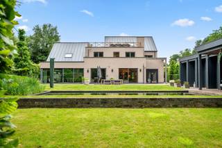 Deze uitzonderlijke villa is gelegen in een rustige, doodlopende straat met vrij uitzicht op groen, in de nabijheid van de golf van Keerbergen.<br /><br />Bij het betreden van de woning komt u in de inkomhal, voorzien van een gastentoilet en vestiaire(kamer). Vanuit de hal bereikt u de ruime en lichtrijke leefruimte met open haard en toegang tot een apart, overdekt terras dat afsluitbaar is en eveneens beschikt over een sfeervolle open haard. Aansluitend bevindt zich een bureauruimte, terwijl de leefruimte naadloos overgaat in de hyper-geïnstalleerde keuken, uitgerust met onder andere een gasfornuis, teppanyaki-plaat en wijnkoelkast.<br /><br />Verderop bevindt zich een polyvalente ruimte van maar liefst 72 m². Deze ruimte is een groot binnenzwembad dat opnieuw geactiveerd kan worden en vandaag ingericht is als een lounge ruimte en bureau. Daarnaast vindt u op het gelijkvloers ook een aparte badkamer met ligbad, dubbele lavabo en toilet.<br /><br />Op de eerste verdieping komt u via de ruime nachthal met ingemaakte kasten bij drie volwaardige slaapkamers, een master bedroom met eigen dressing en privéterras, en een badkamer met ligbad, inloopdouche, dubbele lavabo en toilet. Tevens is hier een aparte wasruimte voorzien.<br /><br />Via een vaste trap bereikt u de zolderverdieping, die volledig is ingericht en perfect dienst kan doen als extra slaapkamer, bureau of hobbyruimte. Aansluitend vindt u hier een royaal dakterras met een prachtig uitzicht op de aangelegde tuin.<br /><br />De villa is volledig onderkelderd en uitgerust met een domoticasysteem en geïntegreerd surroundsysteem. De tuin is mooi aangelegd en beschikt over een poolhouse met zwemvijver.<br /><br />Extra troeven:<br /><br />· Domoticasysteem<br /><br />· 2 laadpalen voor elektrische wagens<br /><br />· 5 airco-units<br /><br />· Poolhouse aan een vijver en extra tuinhuis <br /><br />· Alarmsysteem<br /><br />Voor een gedetailleerd overzicht van de indeling en nog veel meer, raden we je aan om onze website te bezoeken voor de grondplannen op www.imovastgoed.be. Voor verdere informatie en vragen, aarzel niet om contact op te nemen met Jean Heylen via jean.heylen@imovastgoed.be of bel naar 015/34.34.54.