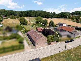 Niets aan het zicht vanop de straat laat vermoeden welk uniek pand achter deze (dikke)muren verscholen ligt. Links van het perceel is er een...