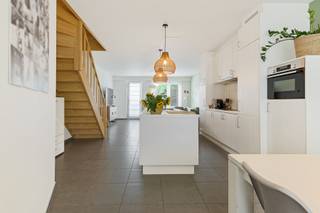 Deze recente woning combineert een doordachte gezinsindeling met vier volwaardige slaapkamers, een aangename tuin en opvallend veel praktische ruimte. De Verbertstraat geniet van een centrale ligging in Schoten, op korte afstand van het centrum en het groene Gemeentepark. Winkels, scholen en dagelijkse voorzieningen bevinden zich vlakbij, terwijl ook het jaagpad langs het kanaal mooie wandel- en fietsmogelijkheden bieden. Zo combineert deze locatie een vlotte bereikbaarheid met verrassend veel groen en ontspanning in de onmiddellijke omgeving.<br /><br /><strong>Indeling</strong><br />Via de inkomhal met vestiairegedeelte en gastentoilet bereikt u de leefruimtes. Vooraan bevindt zich de eetkamer, terwijl de zithoek achteraan werd ondergebracht en zo een aangename, meer private plek vormt met zicht richting tuin.<br />Centraal ligt de geïnstalleerde keuken, die beide leefruimtes op een natuurlijke manier met elkaar verbindt. Zo ontstaat een praktische indeling waarbij koken, eten en ontspannen elk hun eigen plek krijgen, zonder het contact tussen de ruimtes te verliezen.<br /><br /><strong>Eerste verdieping</strong><br />De nachthal geeft toegang tot drie slaapkamers, waaronder een ruime hoofdslaapkamer aan de voorzijde. Verder bevinden zich hier de badkamer, een afzonderlijk toilet en een praktische wasplaats. Ook de technieken voor centrale verwarming en ventilatie werden netjes geïntegreerd.<br /><br /><strong>Zolder</strong><br />De volledig ingerichte zolderverdieping vormt een royale <strong>vierde slaapkamer</strong> en beschikt over ingemaakte kasten. Door de ruime oppervlakte kan deze verdieping desgewenst ook verder worden opgedeeld of gecombineerd worden met een bureau- of dressinggedeelte.<br /><br /><strong>Buitenruimte</strong><br />Achteraan beschikt de woning over een aangename tuin. Een bijkomende troef zijn de <strong>twee garages</strong>, die rechtstreeks via de tuin bereikbaar zijn en aan de achterzijde afzonderlijke toegang hebben via de Kalstraat, bijzonder praktisch voor parkeren, fietsen en extra bergruimte.<br />Onder de volledige woning bevindt zich bovendien een kruipruimte.<br /><br /><strong>Bijzonderheden</strong><br />Met <strong>vier slaapkamers, EPC B, twee garages en een recente bouwkwaliteit</strong> is dit een bijzonder complete woning voor wie ruimte, energiezuinigheid en dagelijks wooncomfort wil combineren.